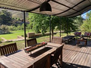 a wooden deck with a table and chairs on it at Riverbend Farm in Robertson