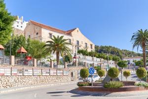 a street in a town with palm trees and a building at Casita Frigiliana in Frigiliana