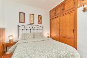 - une chambre avec un grand lit et une porte en bois dans l'établissement Casita Frigiliana, à Frigiliana