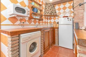 a kitchen with a washing machine and a microwave at Casita Frigiliana in Frigiliana