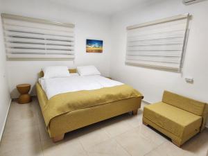 a bedroom with a bed and a chair in it at Extreme Sports Arad in Arad