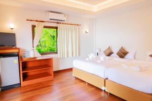 a hotel room with two beds and a television at Lamai bayview boutique resort in Koh Samui 