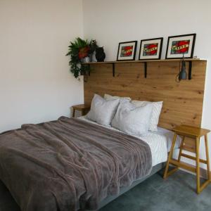 a bedroom with a large bed with a wooden headboard at Maison Tarrade in Châteauneuf-la-Forêt