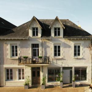 a large white house with a balcony at Maison Tarrade in Châteauneuf-la-Forêt
