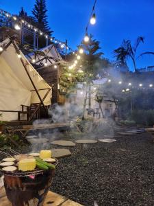 a backyard with a grill with corn and vegetables at Ma Lá Glamping Đà Lạt in Da Lat