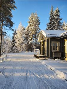 a house in the snow with a driveway at Villa Aleksi in Rovaniemi