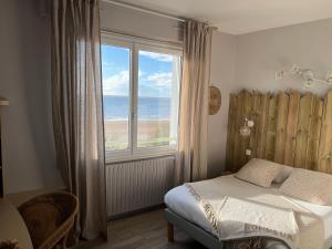 - une chambre avec un lit et une grande fenêtre donnant sur l'océan dans l'établissement Acadie Saint Victor - Hôtel restaurant - Face mer - Chatelaillon plage, à Châtelaillon-Plage