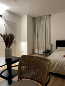 a bedroom with a bed and a table and a chair at Dein Apartment in Hamburg