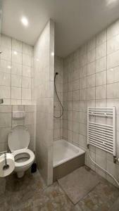 a bathroom with a toilet and a bath tub at Dein Apartment in Hamburg