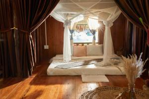 a bedroom with a bed with a canopy at The BanBa Jungle Lodge in Làng Hoa (2)