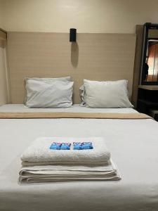 un letto bianco con due cuscini sopra di Losmen Sibayak Berastagi a Berastagi