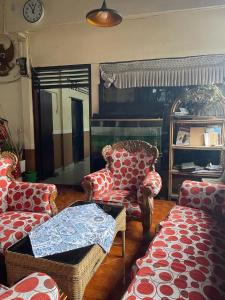 un soggiorno con mobili rossi e bianchi e un orologio di Losmen Sibayak Berastagi a Berastagi