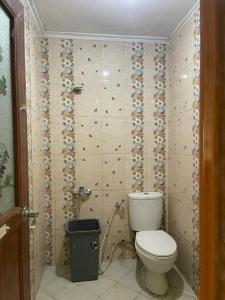 ein Badezimmer mit einem WC und einem Mülleimer in der Unterkunft Losmen Sibayak Berastagi in Berastagi