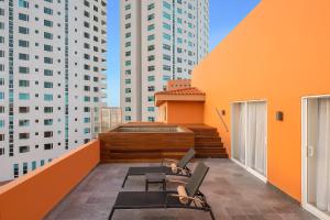 a balcony with chairs and tables on a building with tall buildings at Grand Fiesta Americana Veracruz in Veracruz