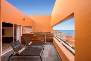Edificio naranja con 2 sillas y balcón en Grand Fiesta Americana Veracruz, en Veracruz