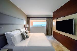 a hotel room with a bed and a flat screen tv at Grand Fiesta Americana Veracruz in Veracruz