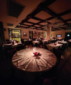 una sala da pranzo con tavolo e fiori di Hotel Mistrello di Savoia a Borgo Val di Taro