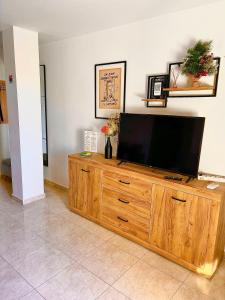 a television on top of a wooden entertainment center at Apartment La Esquina in Denia