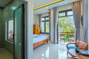 sypialnia z łóżkiem i stołem oraz niektóre okna w obiekcie Phuoc Dat Riverside Homestay Hoi An w Hoi An