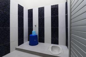 uma casa de banho com um urinol e uma garrafa azul em Wisma Barokah em Tebingtinggi