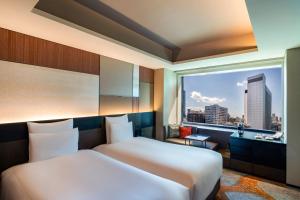 a hotel room with two beds and a large window at Pullman Tokyo Tamachi in Tokyo
