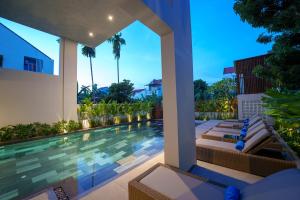uma imagem de uma piscina numa villa em Cozy An Boutique Hotel Hoian em Hoi An