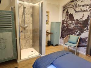 a bedroom with a shower and a blue chair at Schloss Kalteneck in Schwenningen