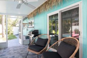 um quarto com duas cadeiras e uma mesa com um fogão em Flamingo Bay Coastal Oasis: Modern Comforts, Heated Pool w/ BBQ em Tampa