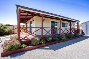 una casa pequeña con porche y algunas plantas en Owen's Hideaway by the BnB Collection en Albany