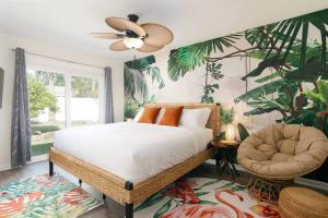 um quarto com uma cama, uma ventoinha e uma cadeira em Flamingo Bay Coastal Oasis: Modern Comforts, Heated Pool w/ BBQ em Tampa