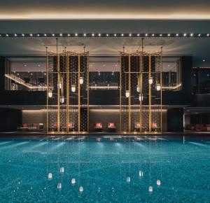 Four Seasons Hotel Suzhou في سوتشو: مسبح كبير في مبنى به انارة