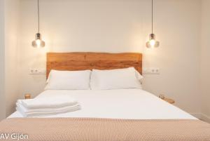 1 dormitorio con 1 cama con sábanas blancas y 2 luces en AV Gijón La Playa 17, en Gijón