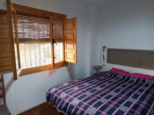 a bedroom with a bed and a window at Casa Pepa in Bubión