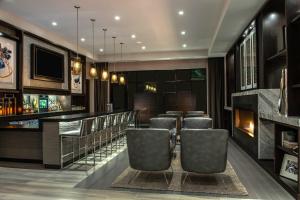 a bar with leather chairs and a fireplace at Fairfield Inn & Suites by Marriott Boston Waltham in Waltham