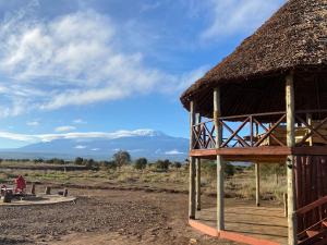 a hut with a thatched roof on a field at Amboseli Discovery Camp in Amboseli