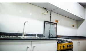 uma cozinha com um fogão amarelo e um lavatório em Housesixapartment em Loburo