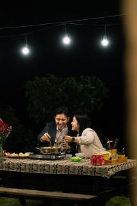a man and a woman sitting at a table at Avatar Homestay & Coffee - Mộc Châu in Mộc Châu