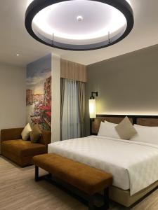 1 dormitorio con 1 cama blanca grande y 1 sofá en Posto Dormire Sudirman en Yakarta