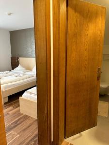 een houten deur in een slaapkamer met een bed bij Hotel Klammer in Vipiteno