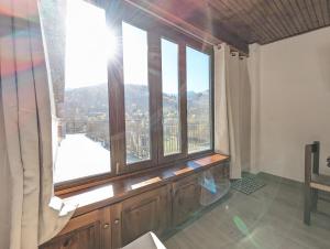 a room with a large window with a view at Mansarda con vista panoramica Limone Piemonte in Limone Piemonte