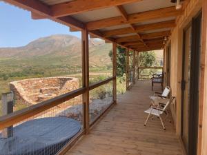 een houten veranda met uitzicht op een berg bij Riverbend Farm in Robertson