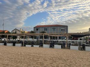 a beach with chairs and a building on the beach at Acadie Saint Victor - Hôtel restaurant -Face mer- Châtelaillon plage in Châtelaillon-Plage