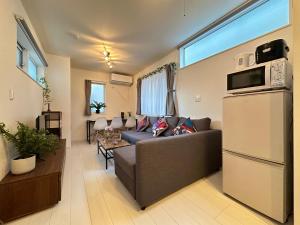 a living room with a couch and a refrigerator at nestay villa tokyo sugamo in Tokyo