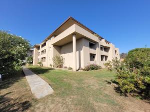ein großes weißes Gebäude mit einem Rasenplatz in der Unterkunft Appartement T2 Bord de Mer - Maria Beach in Santa-Lucia-di-Moriani