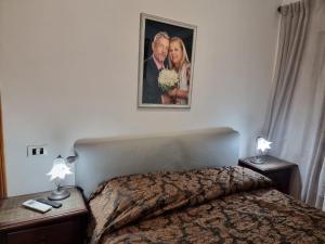 a bedroom with a bed and a picture on the wall at La Casa di Paulina in Cerveteri