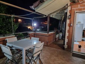 una mesa y sillas en un patio por la noche en La Casa di Paulina, en Cerveteri