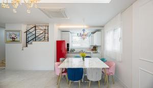 済州市にあるHomechee Kids Poolvillaのダイニングルーム(白いテーブル、ピンクの椅子付)