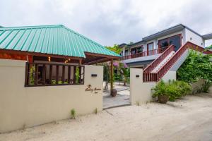 a house with a green roof on the beach at Sunny Breeze View in Hangnaameedhoo