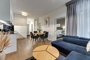 a living room with a blue couch and a table at Downtown Apartments Riverside Granaria Deluxe in Gdańsk