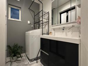 a bathroom with a sink and a toilet and a mirror at nestay villa tokyo sugamo in Tokyo